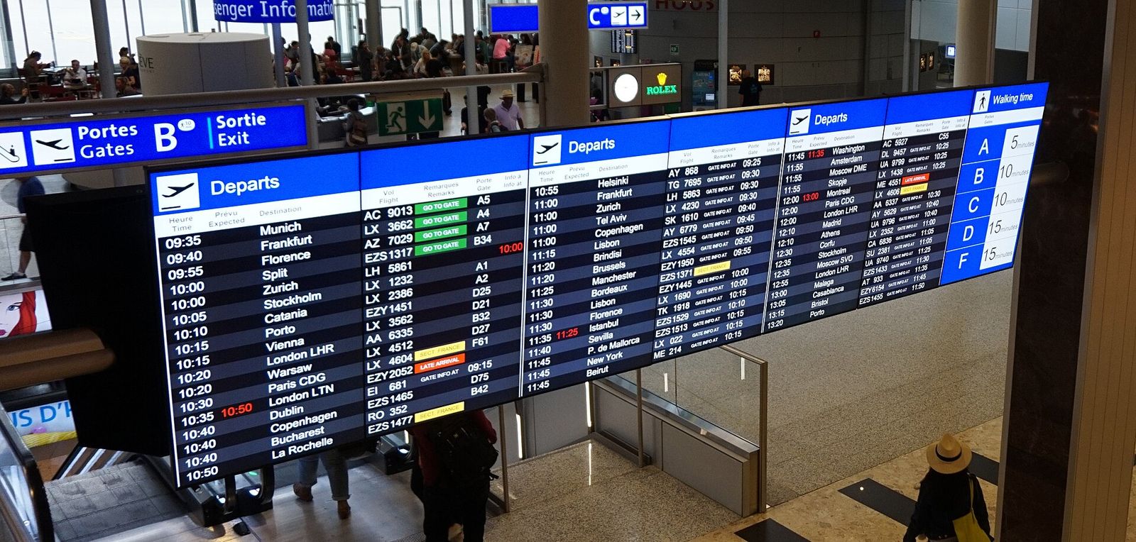 An airport departure board listing flights